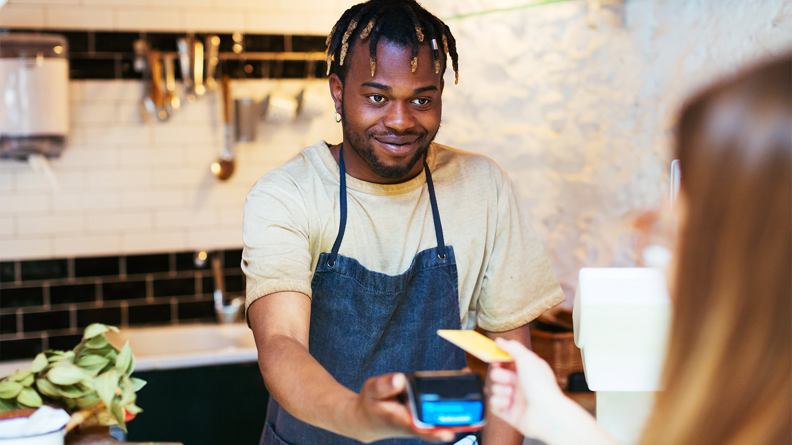 woman paying contactless at cafe