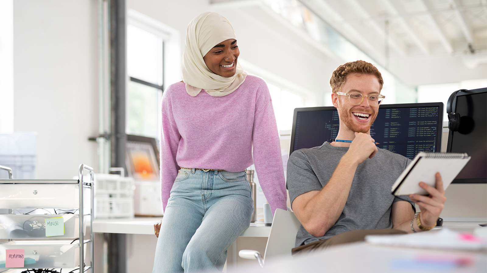 man and woman laughing at desk