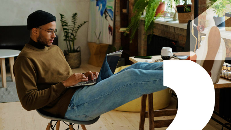 man sat in chair using laptop